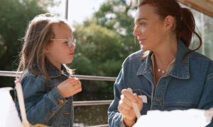 A family enjoys a scenic City Cruises York boat trip along the River Ouse, passing historic landmarks like Clifford’s Tower and York’s medieval walls under the autumn sunshine.